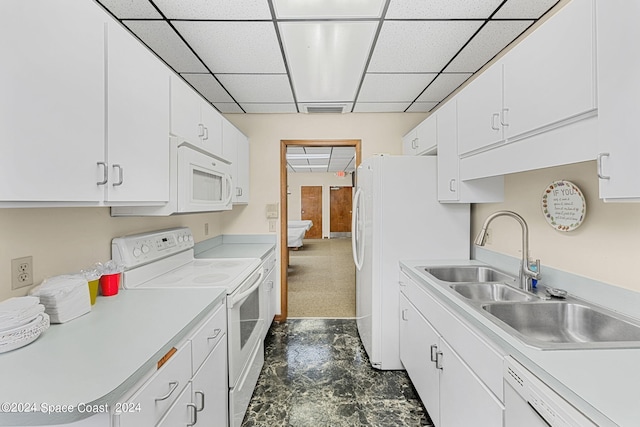 kitchen featuring white appliances, white cabinetry, sink, and a drop ceiling