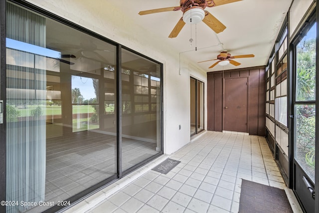 unfurnished sunroom featuring ceiling fan