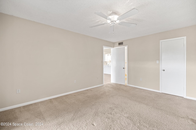 unfurnished room featuring carpet floors, a textured ceiling, and ceiling fan