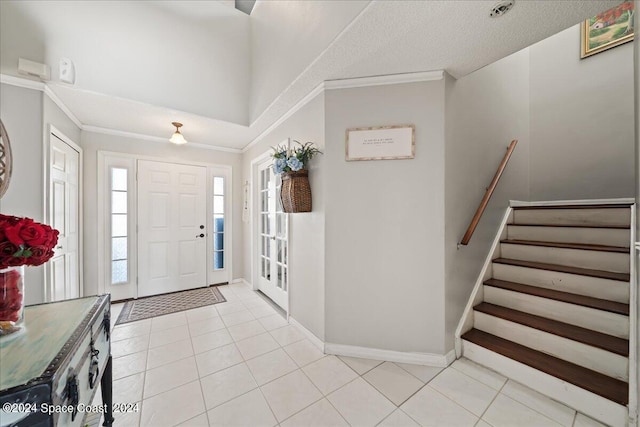 entryway featuring a textured ceiling, crown molding, and light tile patterned floors