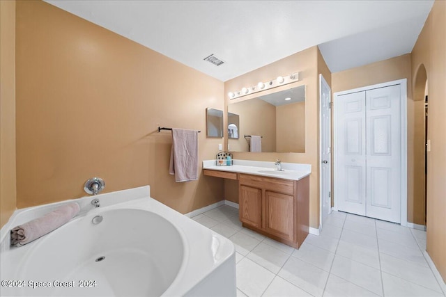 bathroom featuring a tub to relax in, tile patterned flooring, and vanity