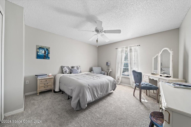 carpeted bedroom with ceiling fan and a textured ceiling