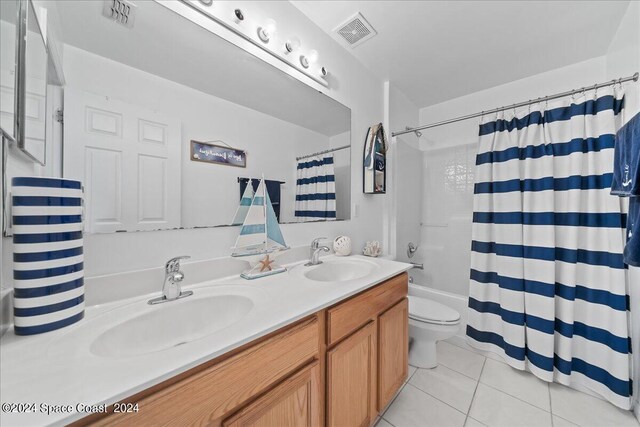 full bathroom with vanity, shower / tub combo, toilet, and tile patterned floors