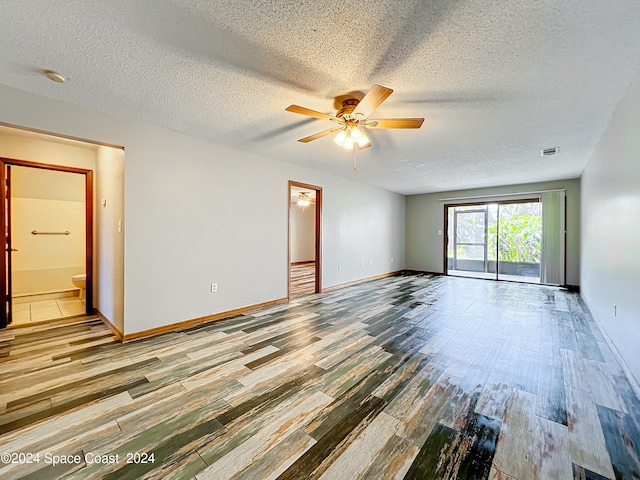 spare room with a textured ceiling, hardwood / wood-style floors, and ceiling fan