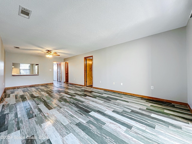 unfurnished room with a textured ceiling, wood-type flooring, and ceiling fan