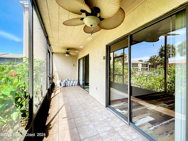 unfurnished sunroom featuring ceiling fan and wooden ceiling