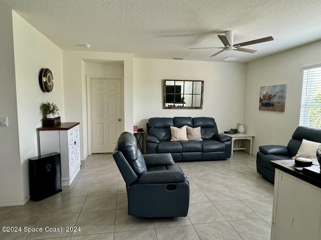 tiled living room with ceiling fan and a textured ceiling