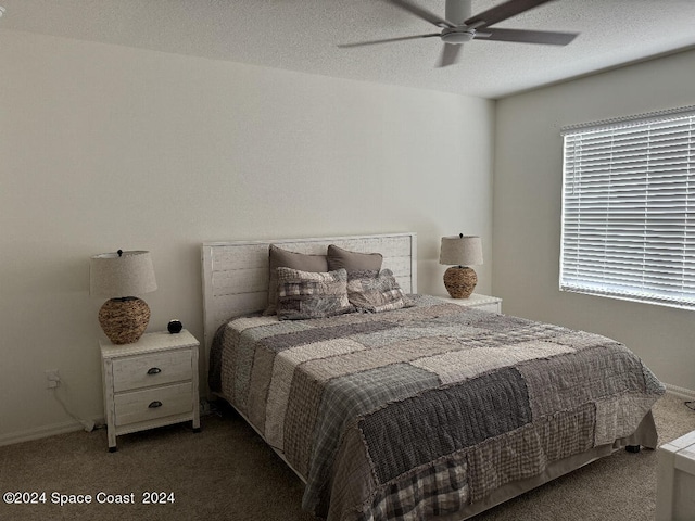 carpeted bedroom with ceiling fan and a textured ceiling