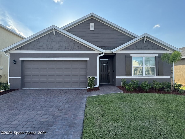 view of front of house featuring a garage and a front lawn