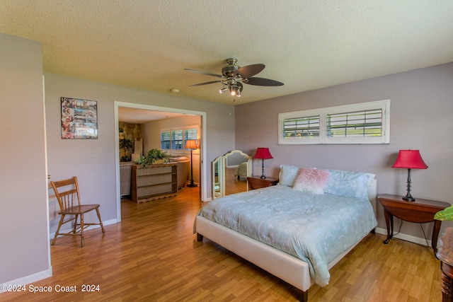 bedroom with light hardwood / wood-style flooring, ceiling fan, and a textured ceiling