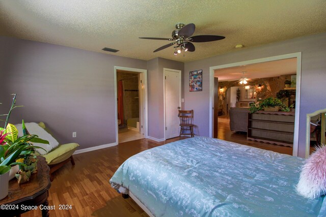 bedroom with connected bathroom, ceiling fan, dark hardwood / wood-style floors, and a textured ceiling