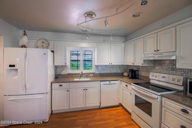 kitchen with light hardwood / wood-style floors, white cabinetry, backsplash, white appliances, and sink