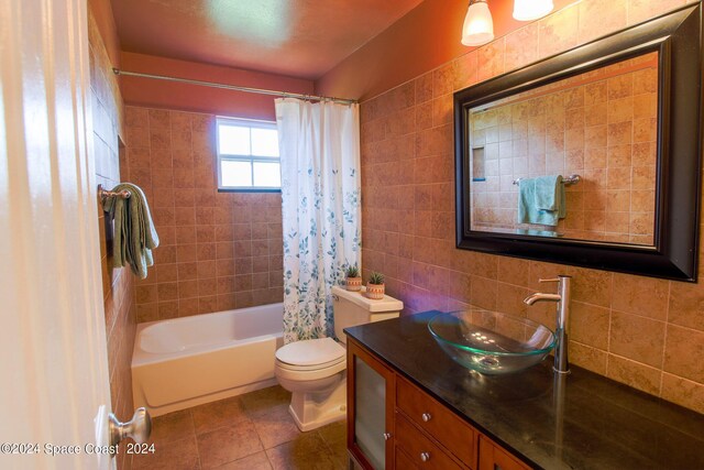 full bathroom with tile walls, shower / tub combo, tile patterned floors, vanity, and toilet