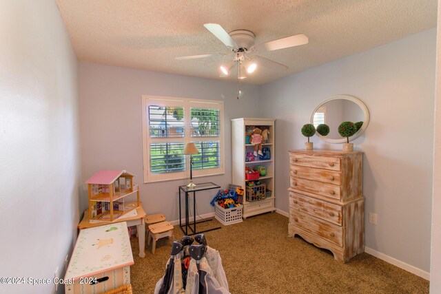 rec room featuring ceiling fan, a textured ceiling, and carpet flooring