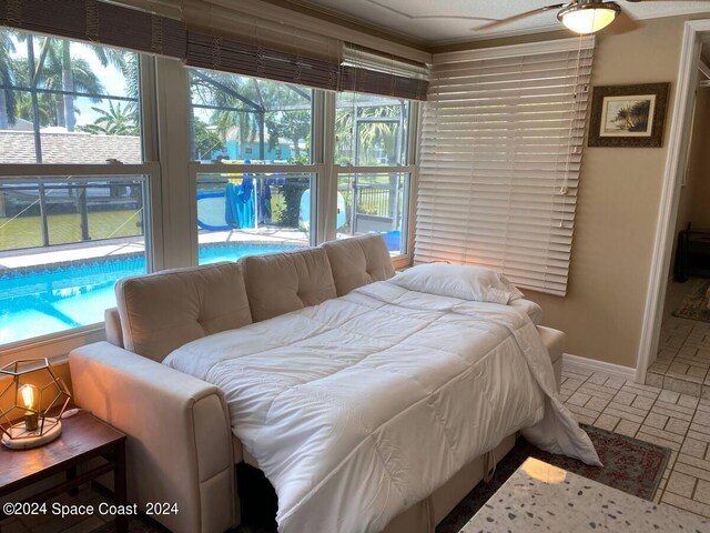 bedroom featuring multiple windows, ceiling fan, and crown molding