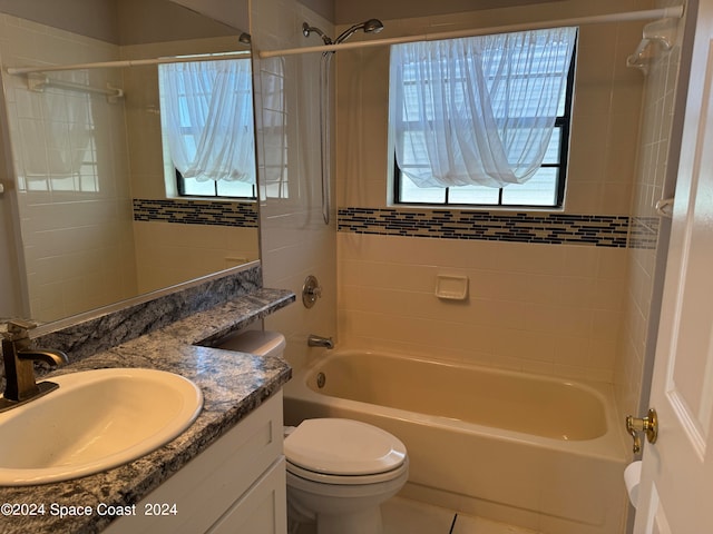 full bathroom with tiled shower / bath combo, vanity, and toilet