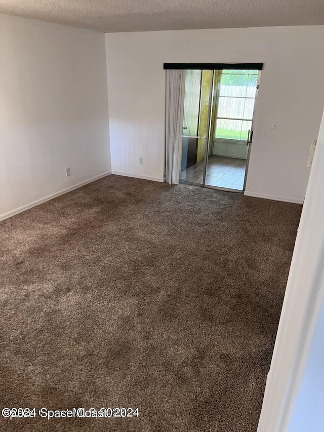 spare room with a textured ceiling and carpet