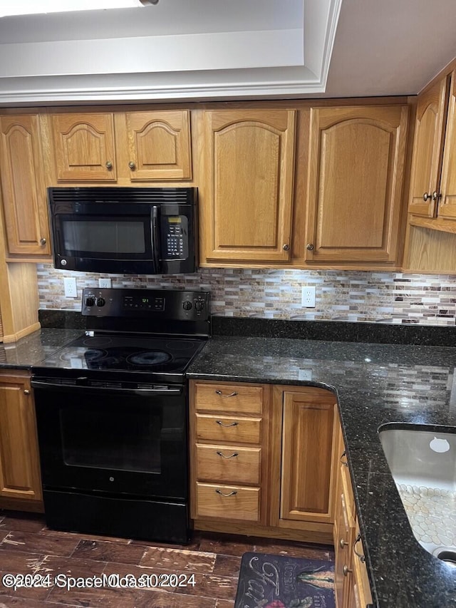 kitchen featuring black appliances, dark stone countertops, decorative backsplash, and dark hardwood / wood-style flooring