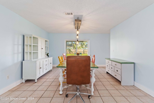 tiled dining area with a textured ceiling