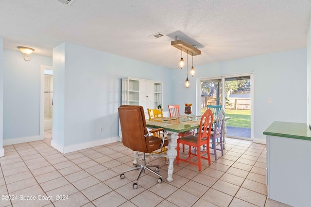 dining space featuring a textured ceiling and light tile patterned floors