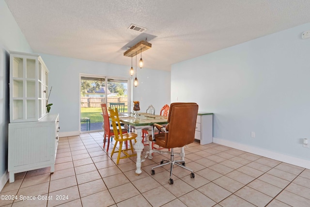 dining area featuring a textured ceiling and light tile patterned floors