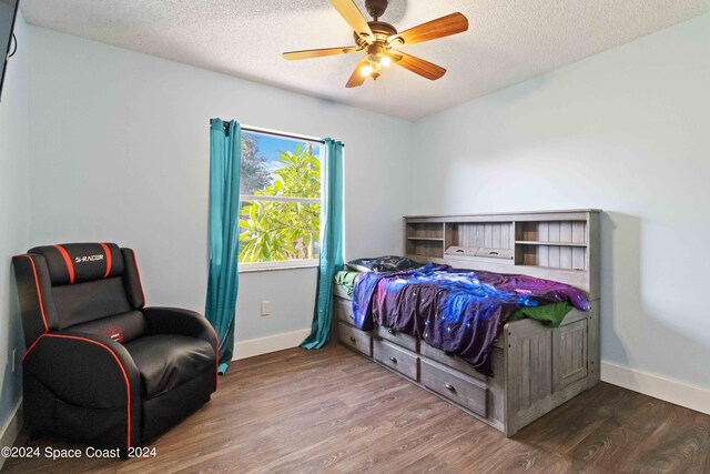 bedroom with ceiling fan, a textured ceiling, and hardwood / wood-style floors