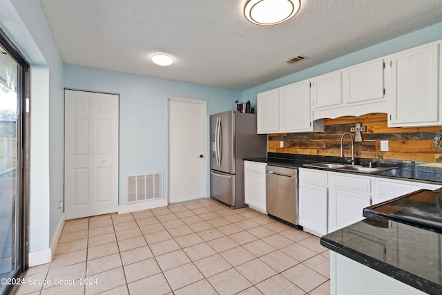 kitchen featuring light tile patterned floors, sink, tasteful backsplash, white cabinetry, and stainless steel appliances