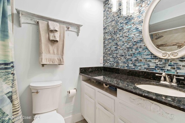 bathroom featuring backsplash, vanity, and toilet