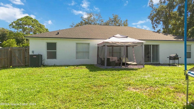 back of house featuring a lawn and central AC