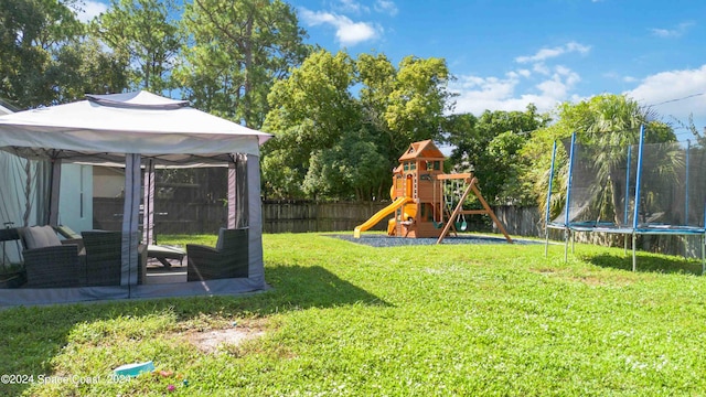 view of yard featuring a trampoline and a playground