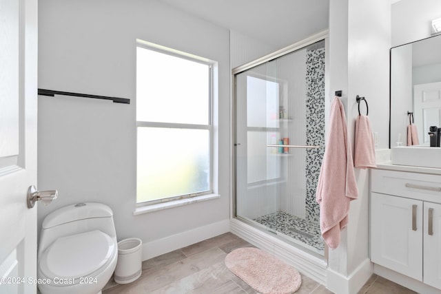 bathroom with wood-type flooring, vanity, a shower with shower door, and toilet