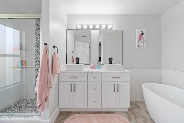 bathroom featuring plus walk in shower, wood-type flooring, and vanity