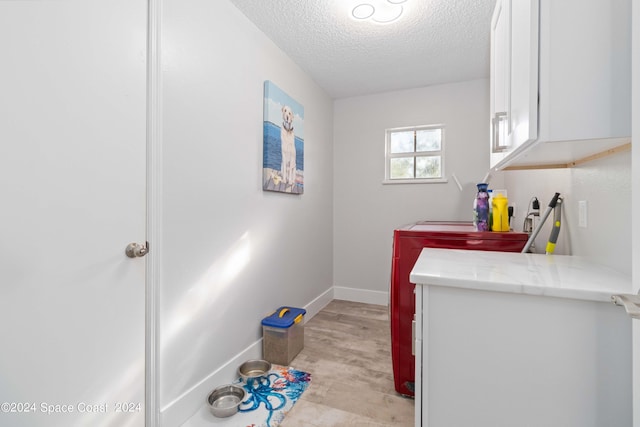 interior space with washing machine and dryer, cabinets, and a textured ceiling