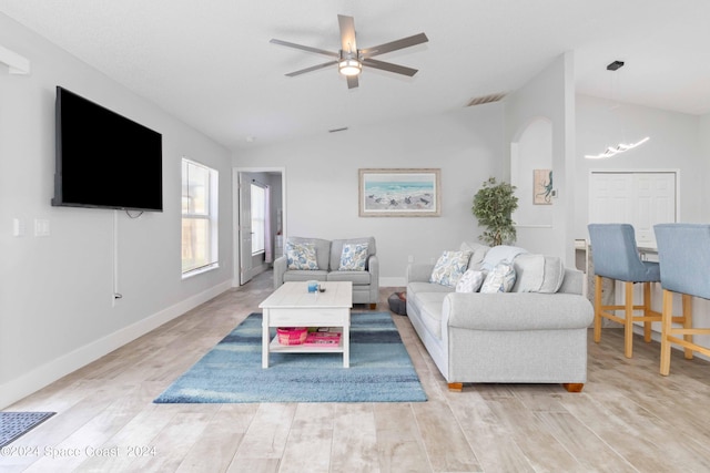 living room featuring ceiling fan, light wood-type flooring, and lofted ceiling