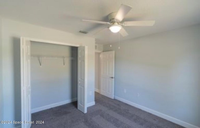 unfurnished bedroom featuring dark carpet, ceiling fan, and a closet