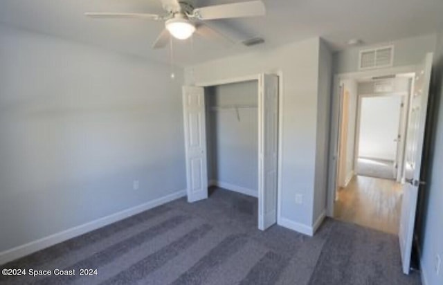 unfurnished bedroom with ceiling fan, a closet, and dark carpet