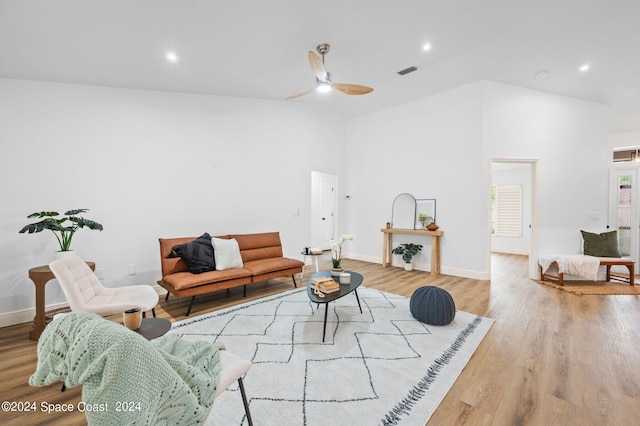 living room featuring high vaulted ceiling, light hardwood / wood-style floors, and ceiling fan