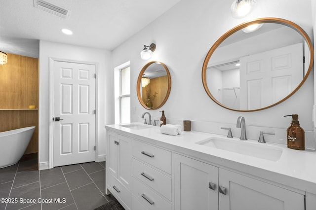 bathroom with vanity, tile patterned floors, and a tub