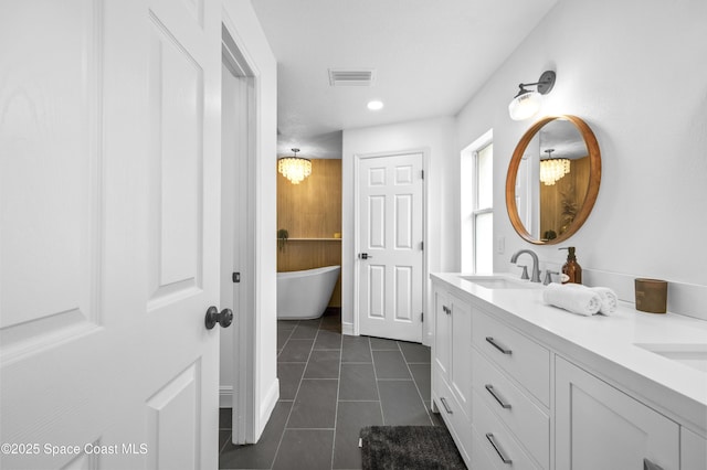 bathroom with vanity, tile patterned floors, and a bathtub