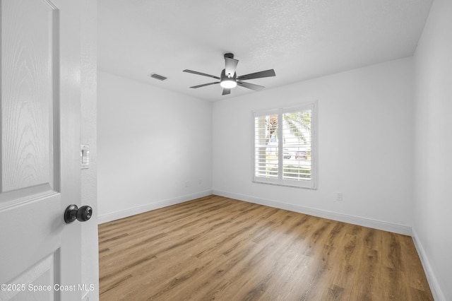 spare room featuring ceiling fan, a textured ceiling, and light wood-type flooring