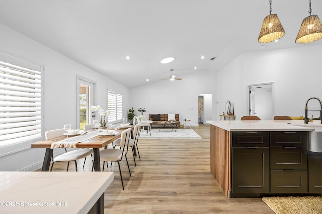 kitchen featuring pendant lighting, ceiling fan, dark brown cabinets, light hardwood / wood-style floors, and vaulted ceiling