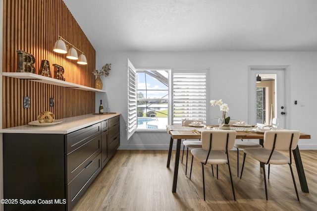 dining space featuring a textured ceiling and light hardwood / wood-style flooring