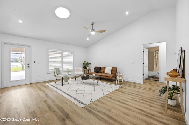 living area with ceiling fan, high vaulted ceiling, and light wood-type flooring