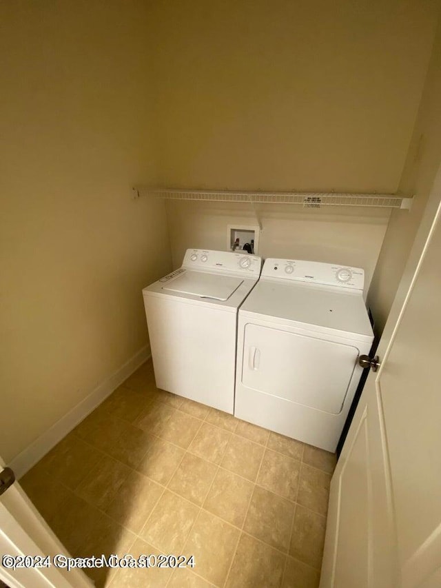 laundry area featuring separate washer and dryer and light tile patterned floors