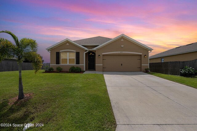 ranch-style home with a lawn and a garage