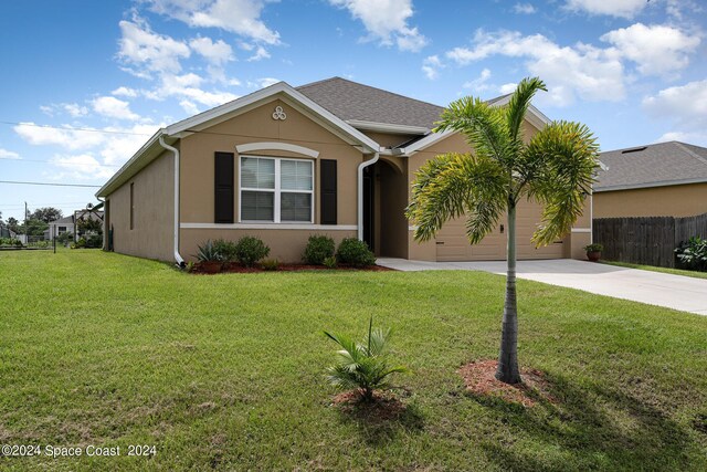 view of front of property featuring a garage and a front lawn