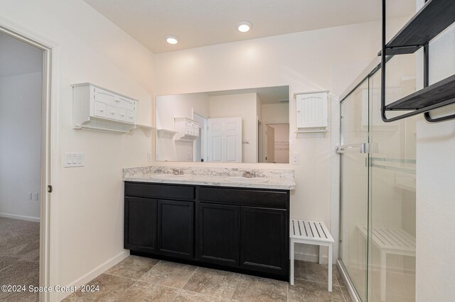 bathroom with vanity and a shower with door