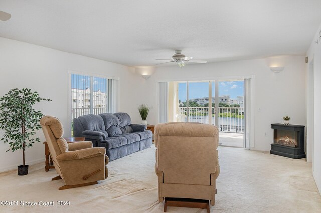 carpeted living room featuring ceiling fan and a multi sided fireplace