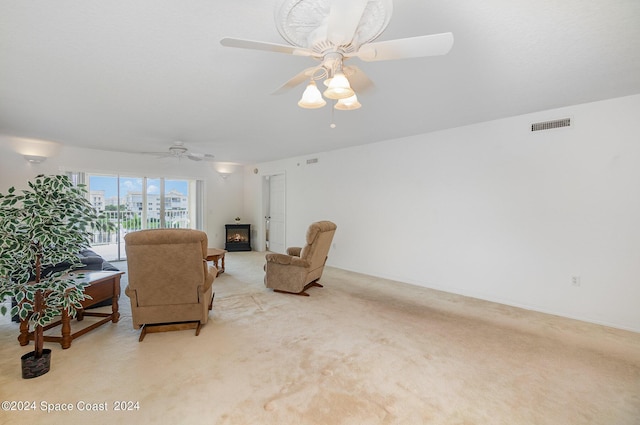 8931 Lake Dr Unit 401, Cape Canaveral, FL 32920 - living room featuring a ceiling fan, light carpet, a glass covered fireplace, and visible vents