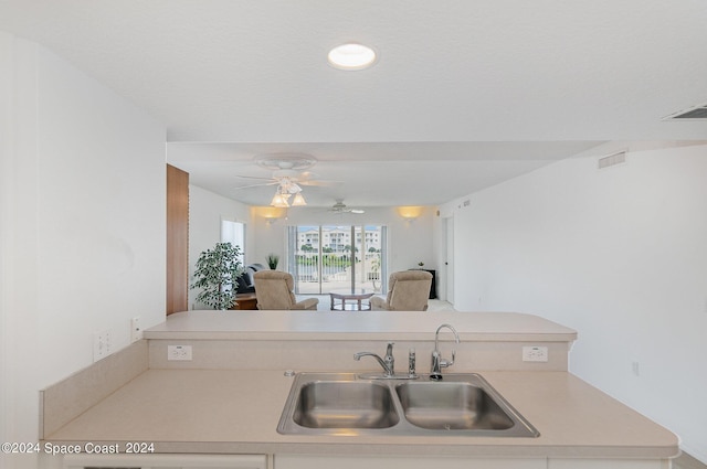 8931 Lake Dr Unit 401, Cape Canaveral, FL 32920 - kitchen with a ceiling fan, light countertops, a sink, and visible vents